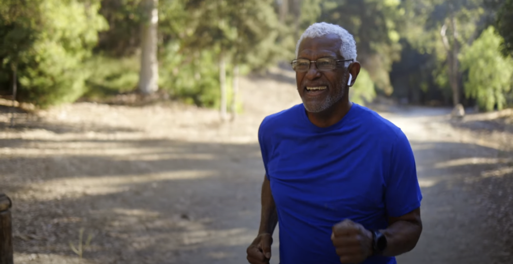 A man in a blue shirt jogging outdoors.
