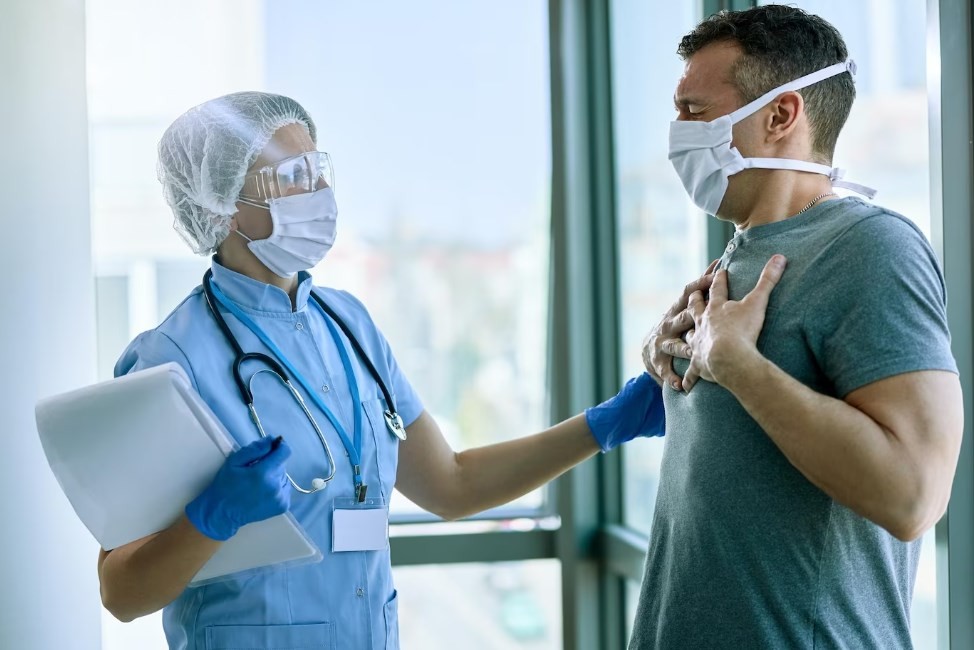 a male patient with lung issues talking to a doctor and complaining of shortness of breath at the hospital