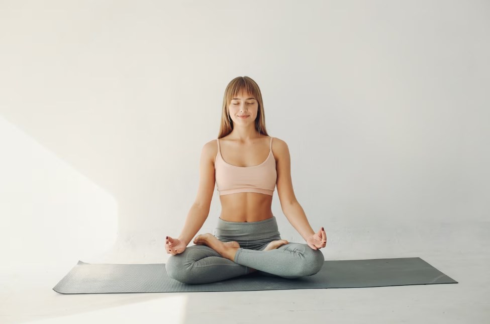 a young sportive girl meditating on a yoga mat