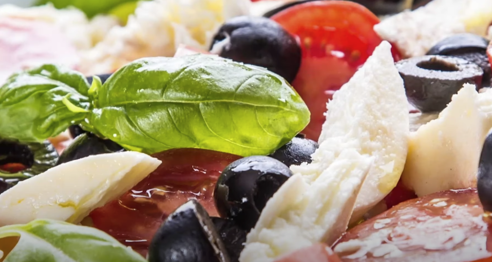 Close-up of a nutritious meal featuring vegetables, leafy greens, and fruits.