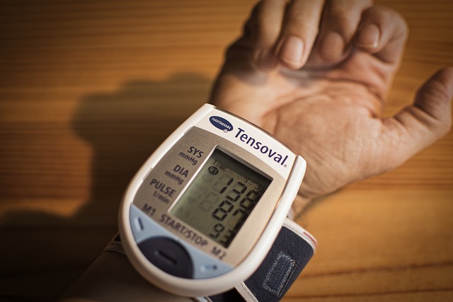 a blood measuring electronic device fixed on a hand showing high blood pressure indicators
